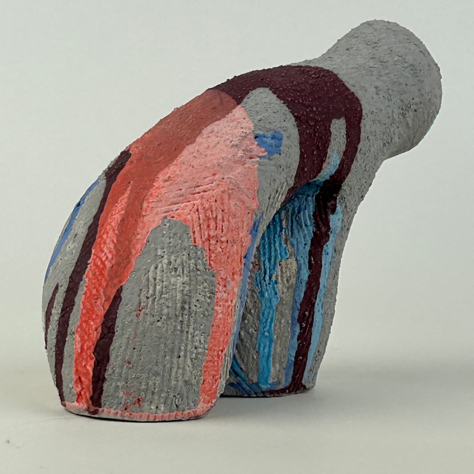 Curving ceramic sculpture in grey with coral, blue and plum glaze running the length of the form in vertical stripes.