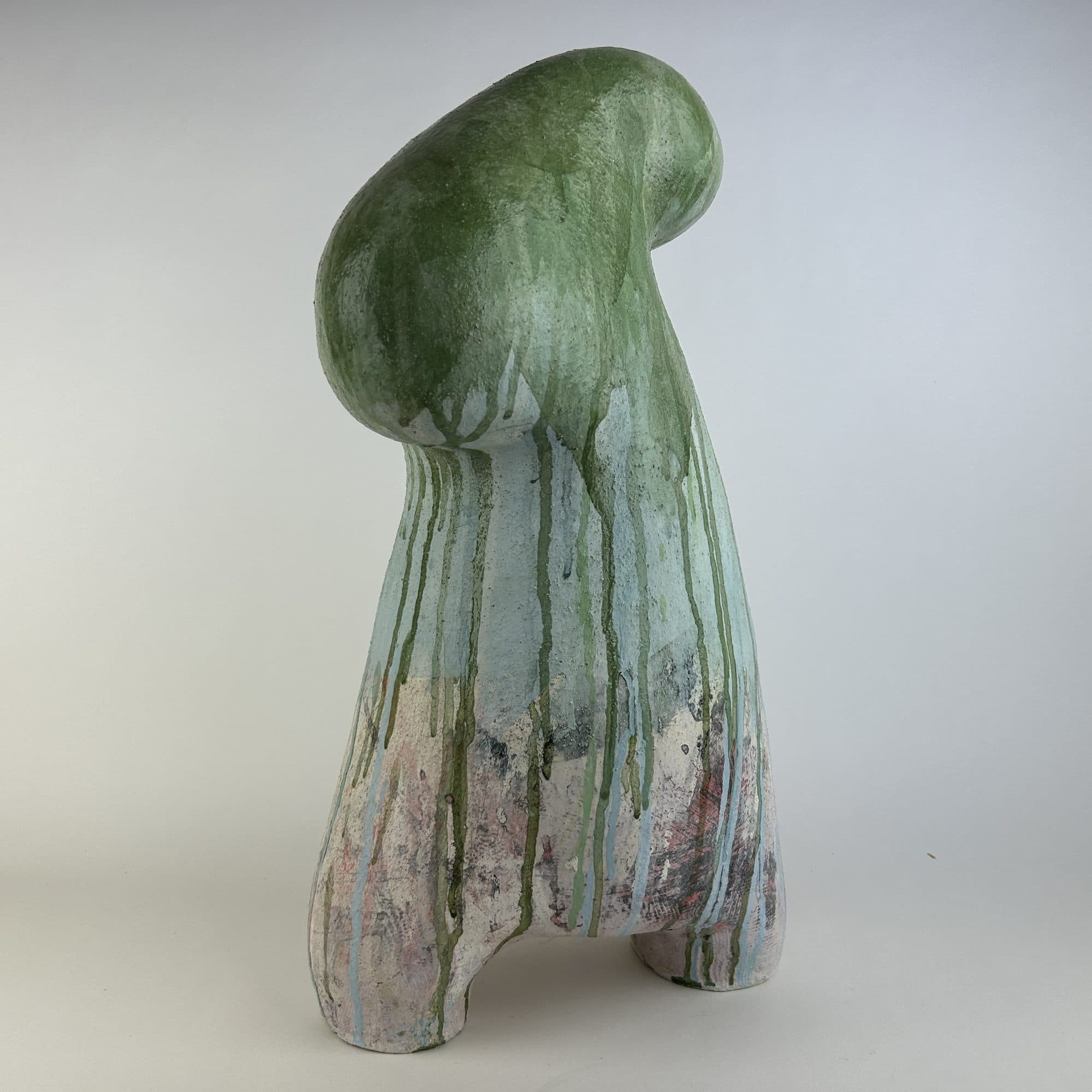 Standing ceramic sculpture with green glaze poured over the crown, breaking into blue and blush beneath.