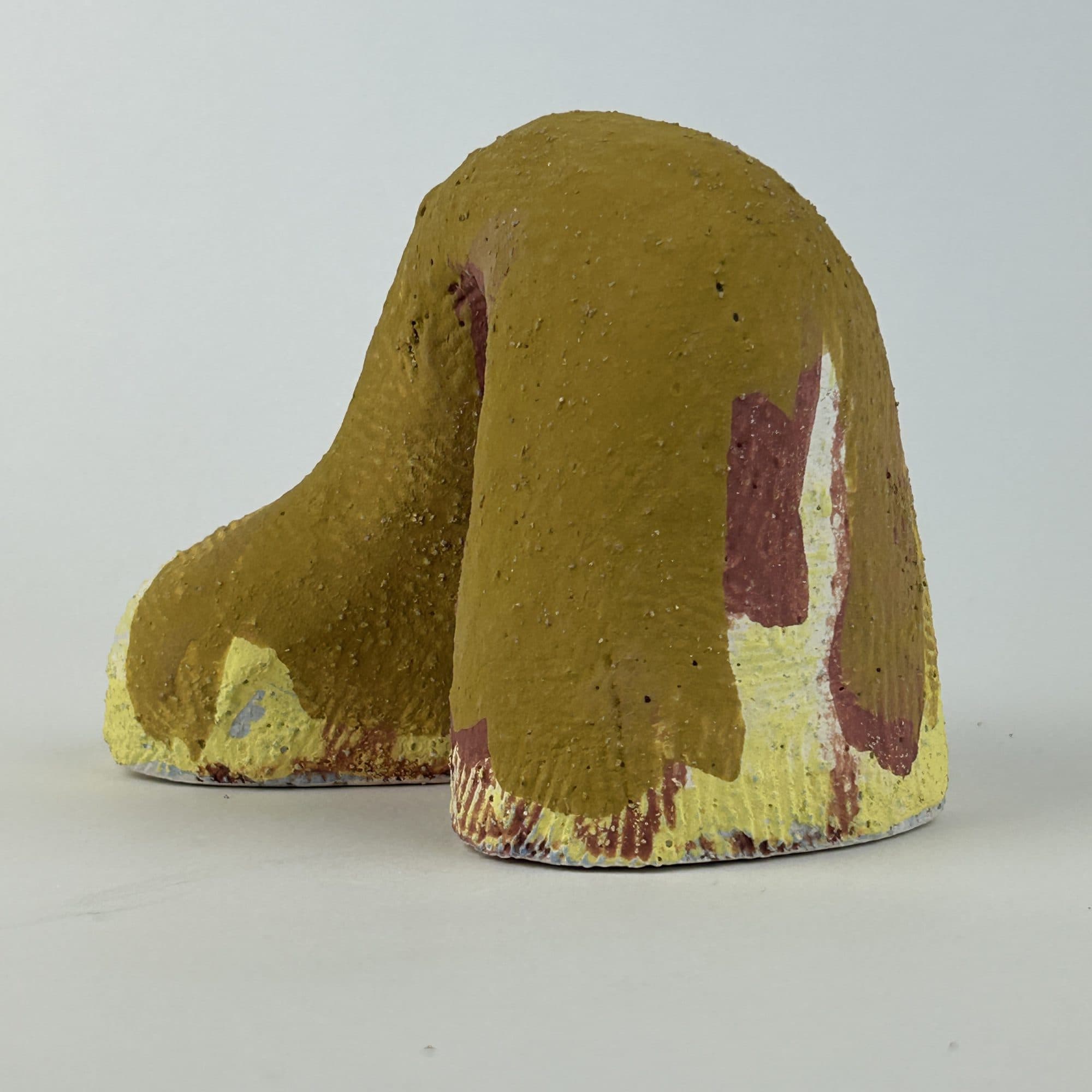 Ceramic arch glazed ochre and yellow, with oxblood and cream breaking through at the base.